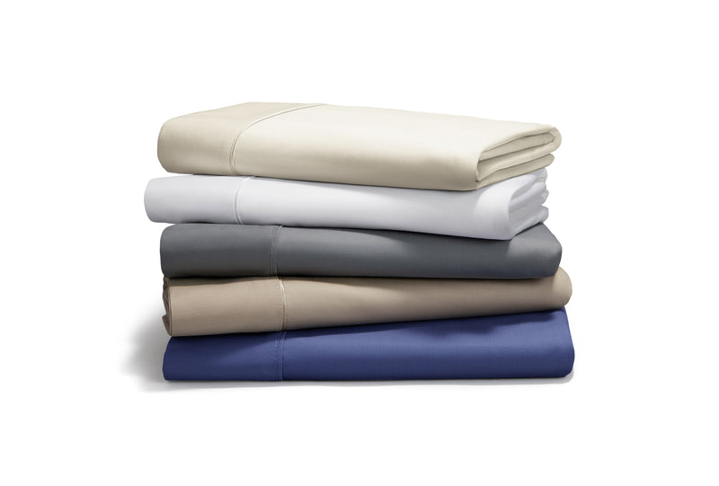 A stack of folded sheets in neutral colors and blue